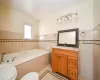 Bathroom featuring tile patterned flooring, vanity, tile walls, and toilet