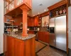 Kitchen featuring sink, stainless steel appliances, decorative columns, kitchen peninsula, and dark stone counters