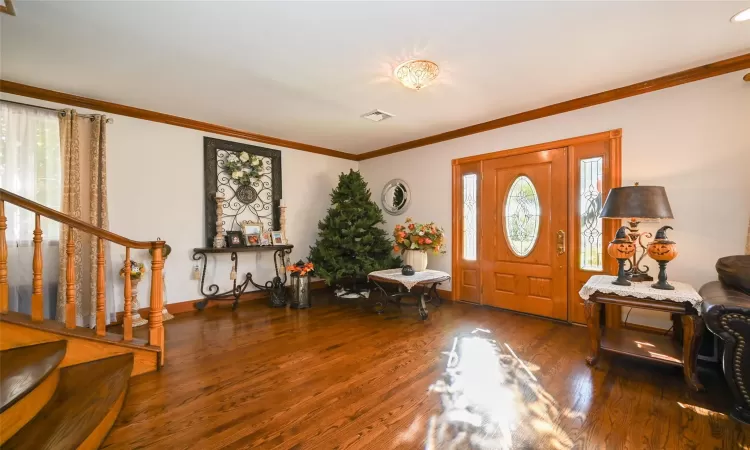 Entryway featuring dark hardwood / wood-style floors and ornamental molding