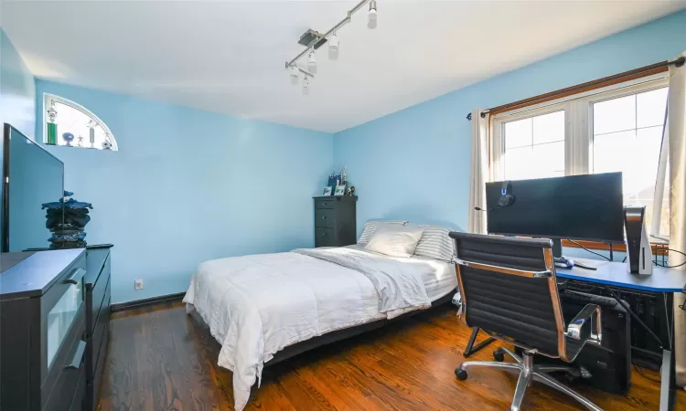 Bedroom featuring track lighting and dark hardwood / wood-style floors