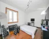 Bedroom with dark hardwood / wood-style floors and rail lighting