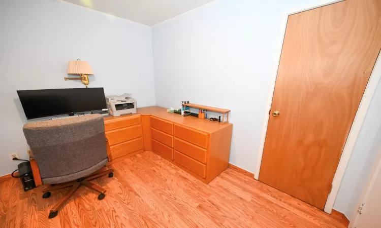 Office space with light hardwood / wood-style floors and crown molding