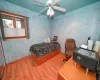 Bedroom featuring hardwood / wood-style floors, ceiling fan, and ornamental molding