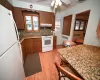 Kitchen with ceiling fan, radiator heating unit, tasteful backsplash, light hardwood / wood-style floors, and white appliances