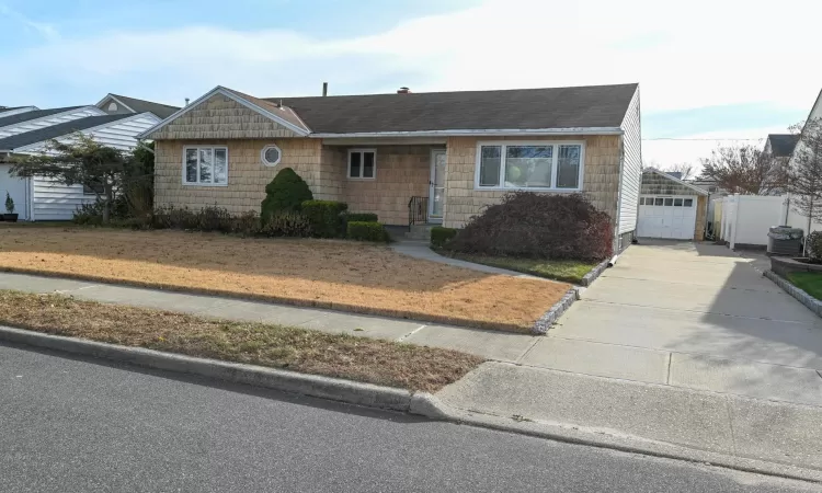 View of front of house with a garage and central air condition unit