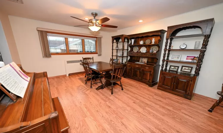 Dining area featuring ceiling fan, radiator heating unit, and light hardwood / wood-style floors