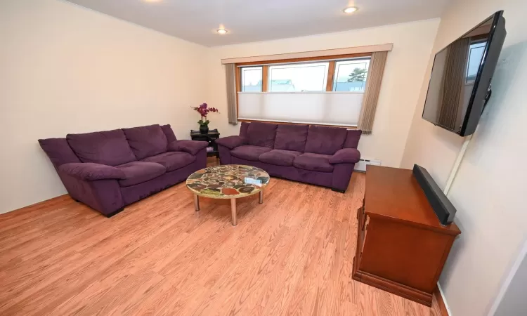 Living room featuring baseboard heating and light wood-type flooring