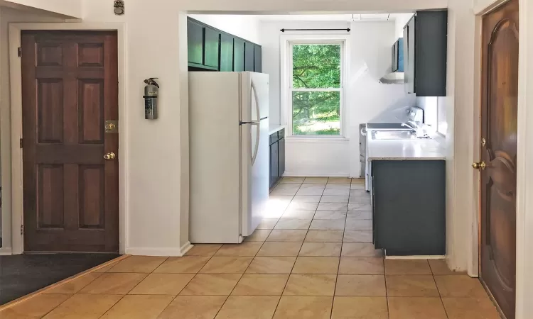 Kitchen featuring white cabinetry, dishwasher, sink, black electric range oven, and light tile patterned floors