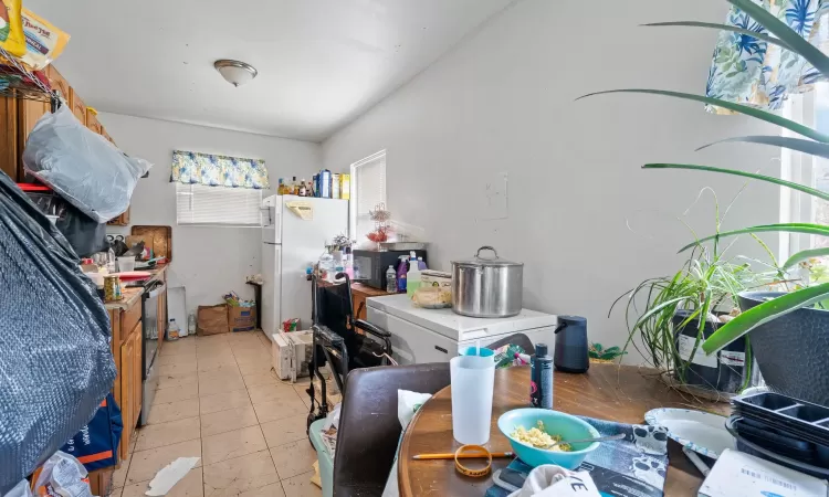 Kitchen with white refrigerator and light tile patterned floors