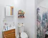 Bathroom with a shower with curtain, vanity, and toilet