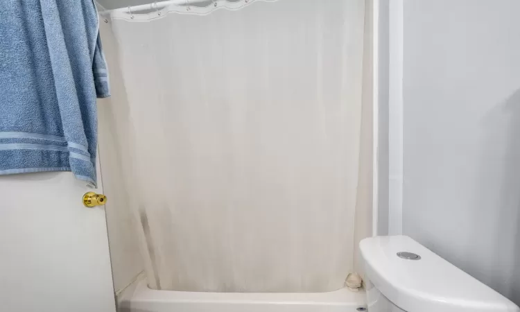 Bathroom featuring shower / bath combo and toilet