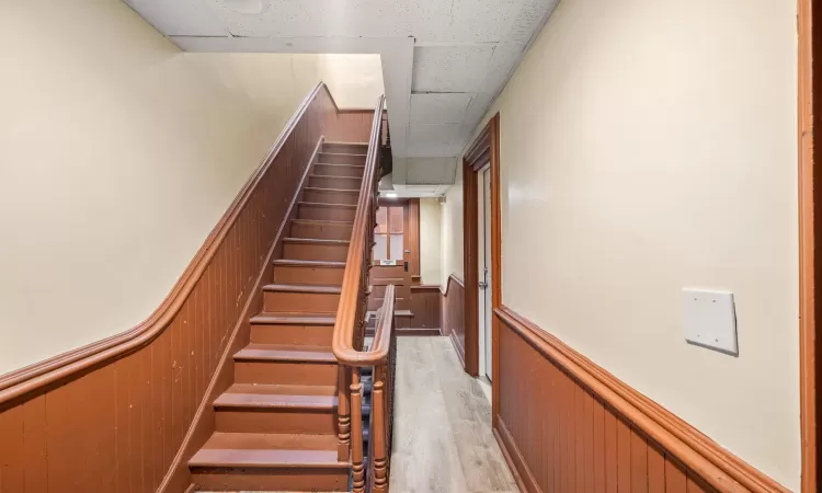 Staircase featuring wooden walls and hardwood / wood-style floors