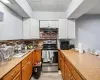 Kitchen featuring stainless steel range with electric stovetop, white cabinets, sink, light hardwood / wood-style flooring, and decorative backsplash