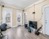 Sitting room featuring crown molding, light hardwood / wood-style flooring, and a baseboard radiator