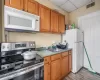 Kitchen with sink, a drop ceiling, white appliances, and light hardwood / wood-style floors