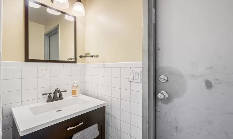 Bathroom featuring vanity and tile walls