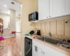 Kitchen featuring sink, white cabinets, light hardwood / wood-style floors, and beverage cooler