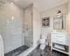 Bathroom featuring tile patterned floors, crown molding, an enclosed shower, toilet, and vanity