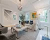 Living room featuring hardwood / wood-style flooring, plenty of natural light, a notable chandelier, and coffered ceiling