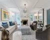 Living room with a fireplace, carpet floors, coffered ceiling, and a notable chandelier