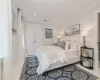 Tiled bedroom with ornamental molding and a closet