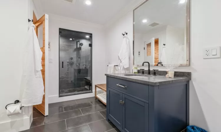 Bathroom with vanity, tile patterned floors, an enclosed shower, and crown molding