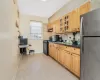 Kitchen with tasteful backsplash, stainless steel fridge, black gas stove, and sink