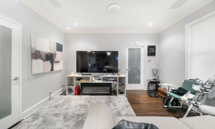 Living room featuring dark hardwood / wood-style flooring and ornamental molding