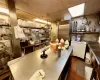 Kitchen featuring dark tile patterned flooring, stainless steel counters, and fridge