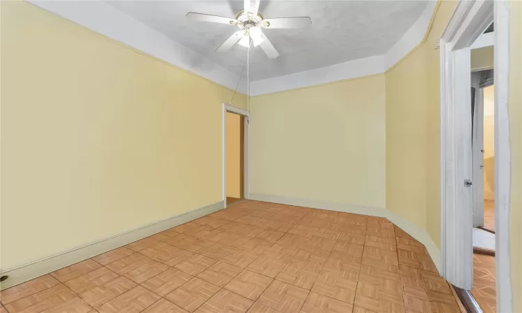 Spare room featuring ceiling fan, a textured ceiling, and light parquet flooring