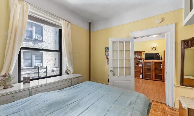 Bedroom with light parquet flooring