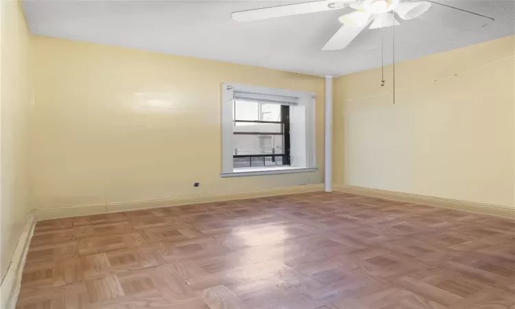 Spare room featuring ceiling fan and light parquet flooring