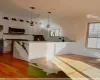 Kitchen featuring pendant lighting, a healthy amount of sunlight, white cabinetry, and light hardwood / wood-style flooring