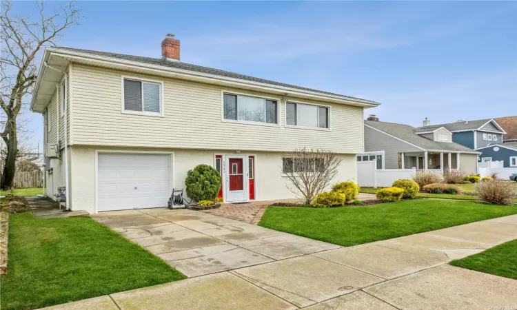 View of front of house with a front yard and a garage