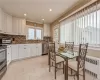 Kitchen featuring radiator, ornamental molding, tasteful backsplash, white cabinetry, and stainless steel appliances