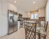 Kitchen featuring decorative backsplash, white cabinetry, light tile patterned flooring, and stainless steel appliances