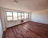 Unfurnished room featuring a textured ceiling, dark hardwood / wood-style floors, and baseboard heating