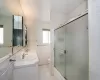 Full bathroom featuring vanity, bath / shower combo with glass door, tile patterned flooring, toilet, and tile walls