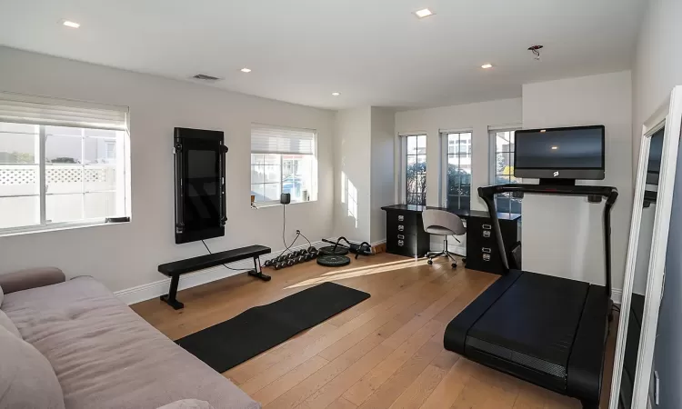 Exercise room with hardwood / wood-style floors