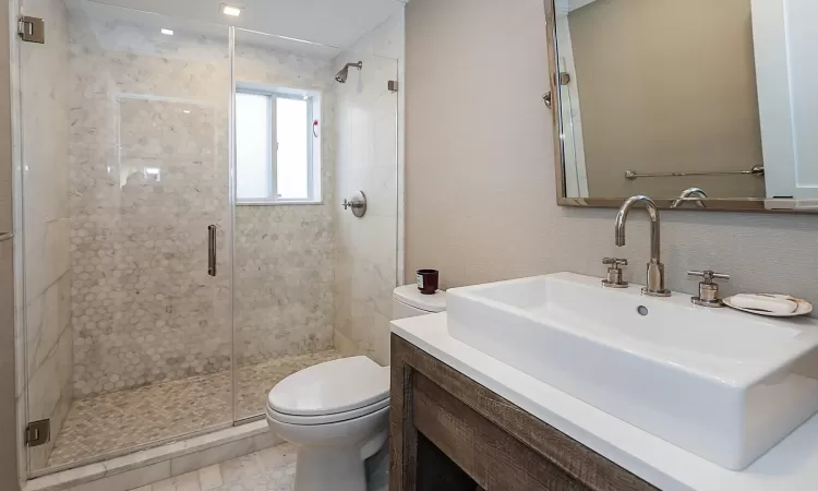 Bathroom with vanity, toilet, and an enclosed shower