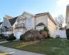 View of front of house featuring a balcony, a front lawn, and a garage