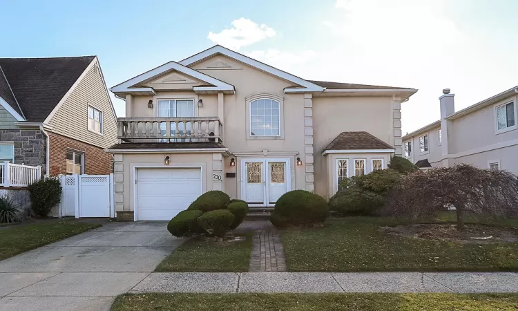 View of front of property with a garage and a balcony