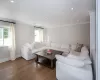 Living room featuring a wealth of natural light, hardwood / wood-style floors, and crown molding