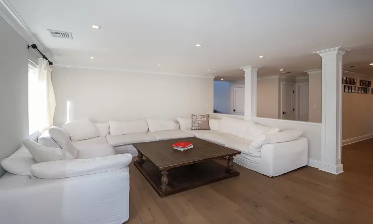 Living room featuring wood-type flooring and ornamental molding