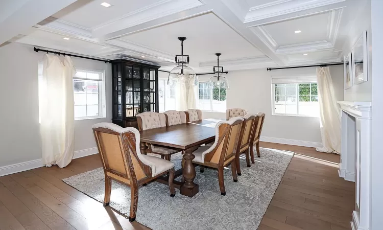 Dining room featuring crown molding, beamed ceiling, dark wood-type flooring, and coffered ceiling