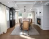 Dining room with beam ceiling, wood-type flooring, coffered ceiling, and ornamental molding