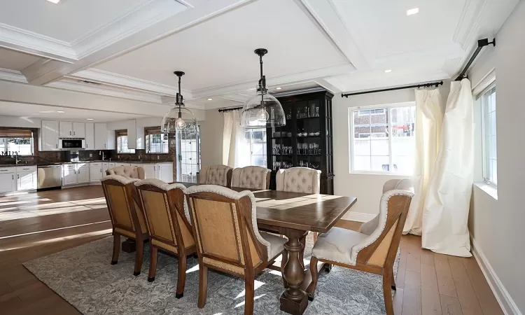 Dining area featuring dark hardwood / wood-style floors, plenty of natural light, and crown molding