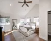 Bedroom featuring multiple windows, high vaulted ceiling, and dark hardwood / wood-style floors