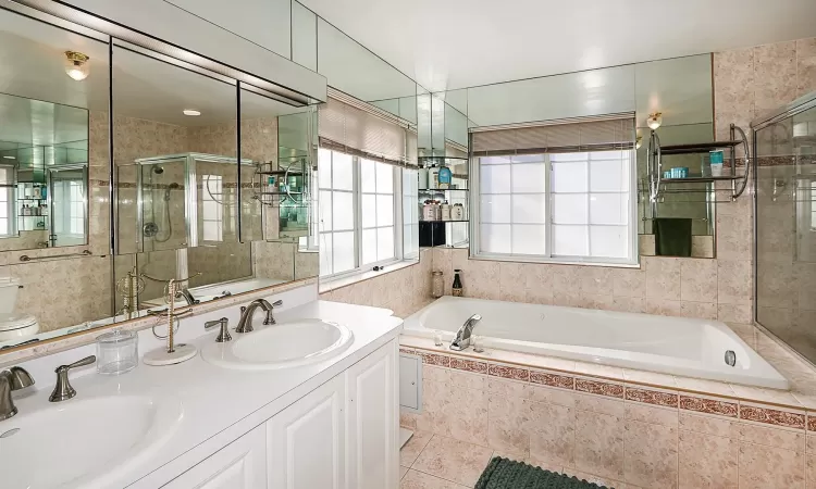 Full bathroom with tile patterned flooring, vanity, toilet, and independent shower and bath