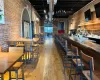 Bar with an AC wall unit, light hardwood / wood-style floors, and brick wall